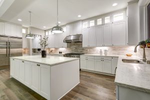 A beautiful modern kitchen with dark wood floors, white cabinetry, and new countertops