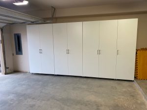 Large, white garage storage system installed in an empty garage 
